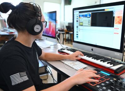 Picture of a women typing on a computer keyboard for an Entertainment Technologies class.